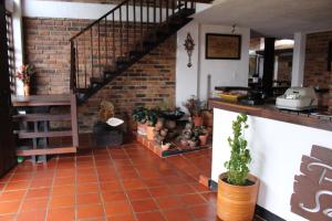 a room with a staircase and a brick wall at Posada San Esteban in Sutamarchán