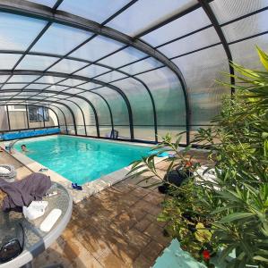 an indoor swimming pool with a greenhouse at Paradise Vibe Balaton in Balatonkenese