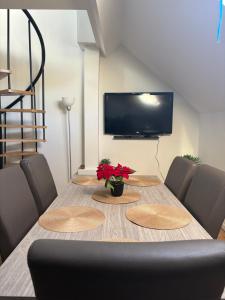 una mesa de comedor con sillas y un televisor en littoral, en Bruselas
