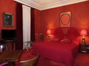 a red bedroom with a red bed and a desk at Hotel Windsor Home in Paris