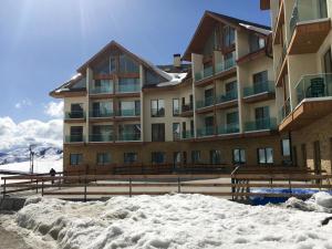 a building with a pile of snow in front of it at Apartments 315 New Gudauri 2 blok in Gudauri