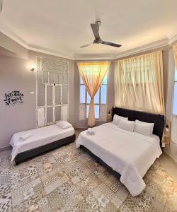 a bedroom with two beds and a ceiling fan at Casa Avelina Boutique Hostel in Santa Marta