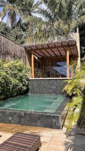 a swimming pool in a backyard with atropominium at Tawa Caraíva in Caraíva