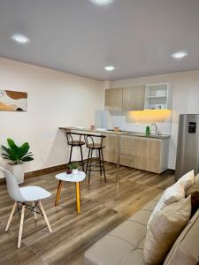a kitchen and living room with a couch and a table at Amazonía Luxury in Florencia
