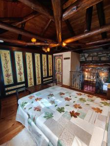 a large bed in a room with wooden ceilings at HerbStone Lodges in Asprangeloi +13 photos