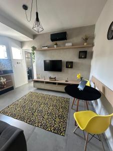 a living room with a television and a table and chairs at Apartamento Completo localizado no centro in Matias Barbosa