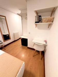 a bedroom with a bed and a desk and a table at Pensión Santa Clara in San Sebastián
