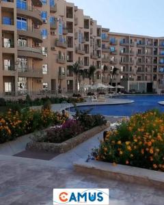 a large apartment building with flowers in a courtyard at CAMUS 354, Princess Resort in Hurghada