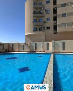 a large swimming pool in front of a building at CAMUS 354, Princess Resort in Hurghada