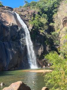 a waterfall in the middle of a body of water at Fusca Home in Piedade