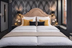 a bedroom with a large bed with gold and white pillows at Cocorico Bed and Breakfast OLD TOWN Szczecin Adults Only in Szczecin