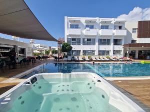 a jacuzzi tub in front of a swimming pool at Cosmo Napa Boutique Hotel in Ayia Napa