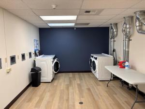 a laundry room with three washing machines in it at Brewster Hall in Cheney