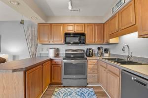 a kitchen with wooden cabinets and a stove top oven at Sandpiper Cay 706 in Kitty Hawk