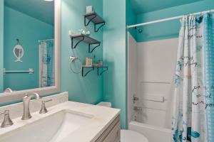 a bathroom with a white sink and a shower at Sandpiper Cay 706 in Kitty Hawk +12 photos