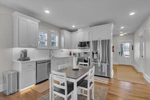 a kitchen with white cabinets and a table and chairs at The Park House in Batesville