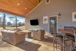 a patio with a table and chairs and a television at The Park House in Batesville