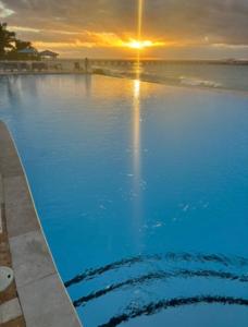 a swimming pool with a sunset in the background at Sunset Bliss in Abbeyville