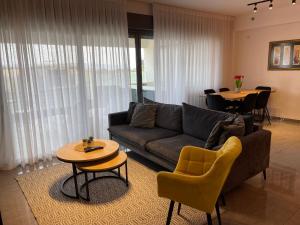 a living room with a couch and a table at סי כנרת- דירות עם בריכה פרטית מבית בלו מגדל in Migdal