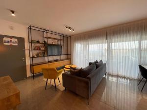 a living room with a couch and a television at סי כנרת- דירות עם בריכה פרטית מבית בלו מגדל in Migdal