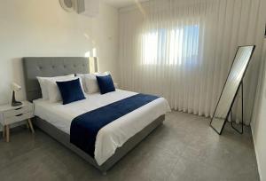 a bedroom with a large bed with blue pillows at סי כנרת- דירות עם בריכה פרטית מבית בלו מגדל in Migdal +16 photos