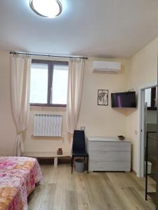 a bedroom with a bed and a desk and a tv at B&B Siena Le Grondaie in Siena