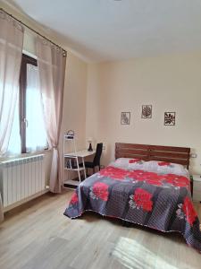 a bedroom with a bed and a table and a window at B&B Siena Le Grondaie in Siena