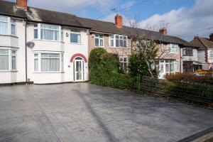 an empty driveway in front of a white house at 4 BD Sleeps 7 Parking WiFi in Coventry