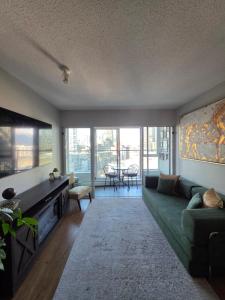 a living room with a green couch and a tv at Charming Abode Downtown Vancouver in Vancouver