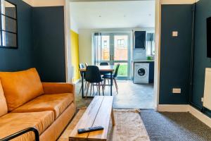 a living room with a couch and a table at 4 BD Sleeps 7 Parking WiFi in Coventry