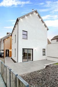 a white house with a fence in front of it at Connel House - Luxury self-catering 4-bedroom home in Connel