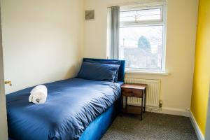 a small bedroom with a blue bed and a window at 4 BD Sleeps 7 Parking WiFi in Coventry
