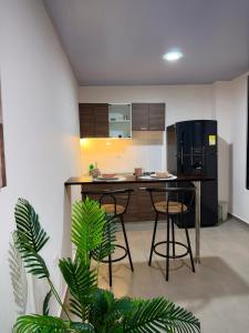 a kitchen with a table and two bar stools at Amazonía Luxury Loft 203 in Florencia