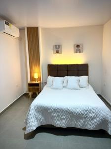 a bedroom with a large bed with white sheets and pillows at Amazonía Luxury Loft 203 in Florencia +5 photos