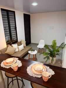 a living room with a table with plates on it at Amazonía Luxury Loft 203 in Florencia