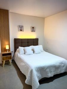 a bedroom with a large bed with white sheets and pillows at Amazonía Luxury Loft 203 in Florencia