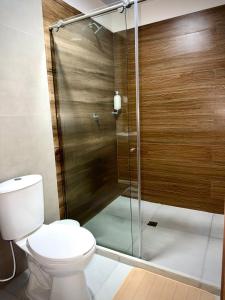 a bathroom with a toilet and a glass shower at Amazonía Luxury Loft 203 in Florencia