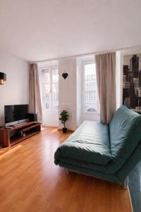 a living room with a couch and a flat screen tv at Central & cosy next to cathedral in Fribourg