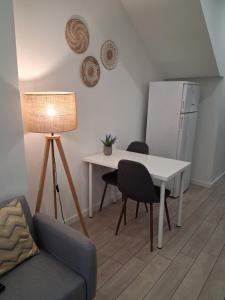 a living room with a table and chairs and a refrigerator at Casa do Hilário in Viseu