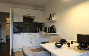 a kitchen with white cabinets and a table and chairs at Ruhiges Nest in Bad Endorf