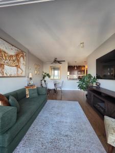 a living room with a green couch and a television at Charming Abode Downtown Vancouver in Vancouver