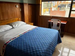 a bedroom with a bed and a desk and a window at Hotel Tropical Club in Estación El Salto