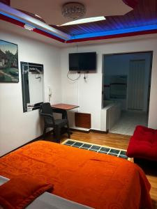 a bedroom with a bed and a desk and a table at Hotel Tropical Club in Estación El Salto