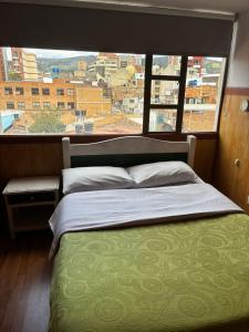 a bed in a room with a large window at Hotel Tropical Club in Estación El Salto