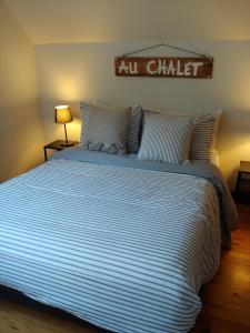 a large bed in a bedroom with a sign on the wall at Le Iris in Saint-Alexis-des-Monts