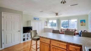 a living room with a kitchen with a counter and a tv at Canal Place 206 in Destin
