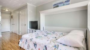 a bedroom with a bed and a flat screen tv at Canal Place 206 in Destin