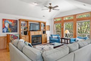 a living room with a couch and a tv at Dragonfly in Southern Shores
