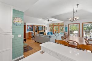 a kitchen and living room with a table and chairs at Dragonfly in Southern Shores