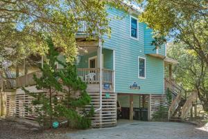 a blue house with a deck and a porch at Dragonfly in Southern Shores